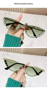 Detailed view of cat-eye sunglasses with gradient green lenses and crystal embellishments