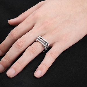 Macro detail of silver mechanical punk ring with industrial gear layers and studs