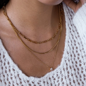 Détail du collier triple rang doré en acier inoxydable avec chaîne trombone et pendentif zircon