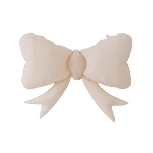Close-up of large matte beige bow-shaped aluminum foil balloon for party decorations