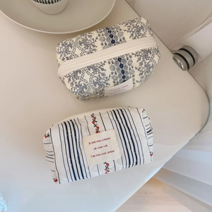 French floral quilted cotton cosmetic bags with cherry patterns on a clean white table