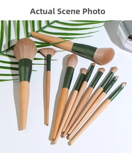 Flat lay of 10-piece wooden makeup brush set with green ferrules and brown soft bristles