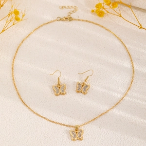Vista dettagliata di un set di collana e orecchini a farfalla placcati oro con zirconi
