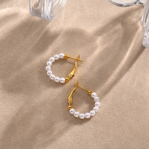 Elegant gold-plated C-shaped hoop earrings with white pearls for women on beige background