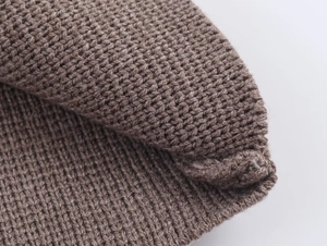 Macro shot of dark camel chunky knit fabric texture with detailed woven stitching pattern