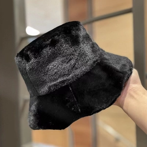Detail shot of soft black faux fur bucket hat showing plush texture and premium finish