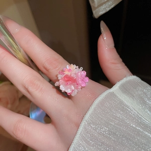 Vista dettagliata di un anello a fiore fatto a mano in resina rosa e bianca sul dito