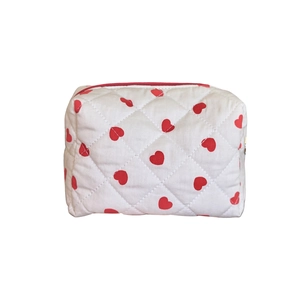 Quilted white cosmetic bag with red heart patterns and zipper for travel organization