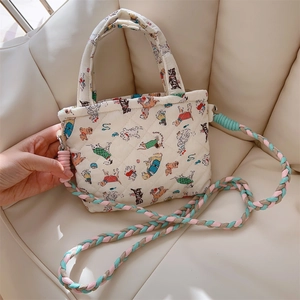 Detail of quilted cotton phone bag with cute dog prints and colorful braided rope strap