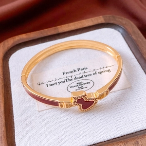 Close-up of golden bear-shaped bangle with maroon enamel and sparkling crystals