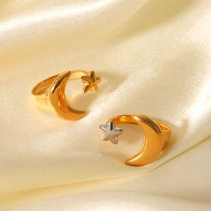 Two-tone celestial star and moon open rings on soft yellow satin silk background