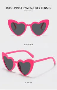 Detail view of heart-shaped sunglasses in rose red frame with gray lenses