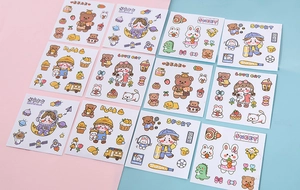 Flat lay of colorful cartoon PVC stickers with bear and astronaut motifs for water bottles