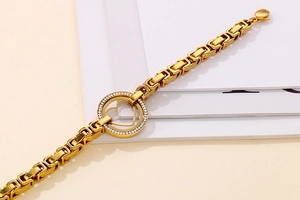 Détail de la chaîne à maillons dorée 18 carats avec un pendentif cœur en strass