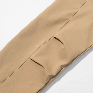 Détail de trench-coat kaki montrant la poche utilitaire et la texture du tissu