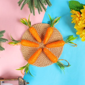 Set of six vibrant orange artificial Easter carrots with green leaves on jute mat