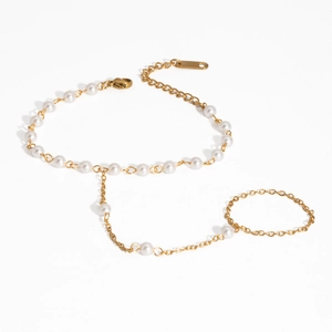 Vue macro du bracelet de doigt en perles dorées montrant le fermoir et l'éclat des perles