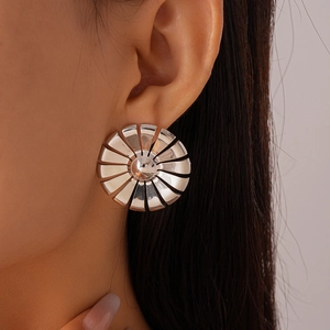 Macro shot of a silver sunburst flower stud earring with polished metal petals