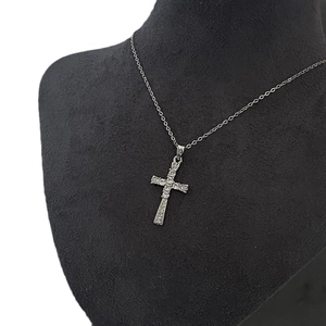 Collier croix en argent avec pendentif zircon blanc sur un présentoir de collier