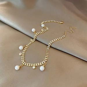 Détail d'un ras-du-cou doré à double rangée de strass avec d'élégantes perles sur satin