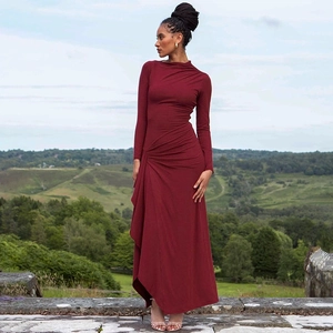 Close-up of wine red long-sleeved dress featuring waist draping and pleated details