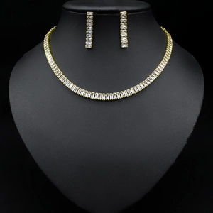 Detail of gold zircon necklace and earrings set with rectangular crystals on bust
