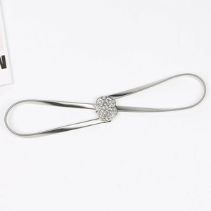 Détail d'une chaîne de taille argentée à ressort avec boucle cœur ornée de strass