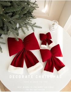 Detailed view of red velvet Christmas bows with white faux fur trim on a festive table