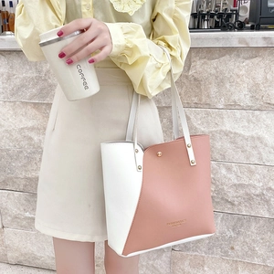 Minimalist color-block tote bag in cream and dusty rose featuring gold rivets and long handles