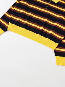Detail of striped knit polo shirt featuring navy and brown stripes with yellow ribbing