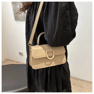 Dettaglio della borsa in pelle PU beige con fibbia dorata a D e manico superiore