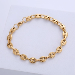 Detailed view of golden coffee bean link bracelet with a lobster clasp on a white stand