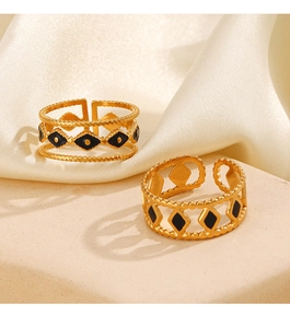 Detail of gold-plated stainless steel hollow rings with black enamel diamond patterns