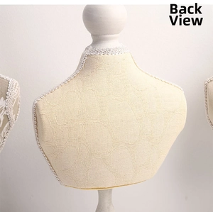 Detail of beige jacquard fabric mini mannequin stand with white lace trim for jewelry