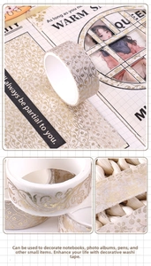 Detail of vintage washi tape with gold foil rose patterns on a creative diary page