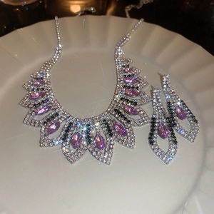 Sparkling silver jewelry set with purple rhinestones on a decorative white dish