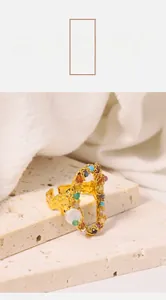 Detail view of gold hammer texture open ring with colorful beads on stone base
