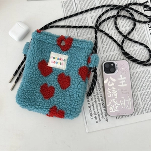 Détail du sac en polaire bleue à motif cœur rouge avec bandoulière tissée élégante