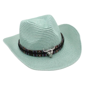 Detail of mint green straw cowboy hat with ethnic geometric band and silver bull skull charm