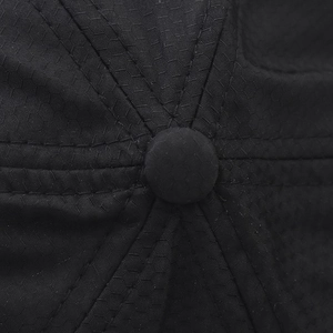 Macro detail of breathable honeycomb mesh fabric and reinforced stitching on a black cap