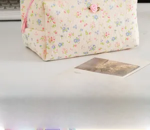 Dettaglio del beauty case floreale con cerniera rosa e ornamento a forma di rosa