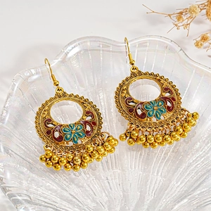 Vintage gold drop earrings with colorful enamel flowers and dangling beads on a glass plate