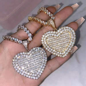 Close-up of gold and silver heart pendants with full pavé stones on tennis chains