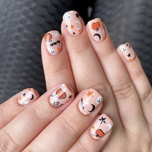 Short Halloween press-on nails set featuring pumpkin, ghost, and bat patterns on pink base