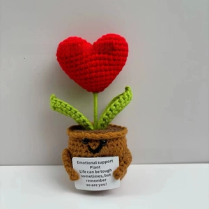 Macro shot of handmade crochet red heart plant with smiling face and support message