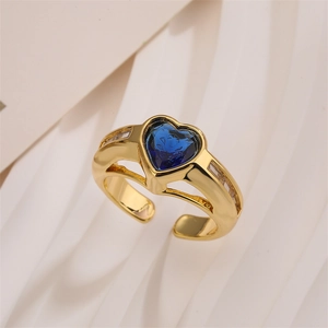 Detail of gold open ring with heart-shaped blue stone and sparkling zircon accents