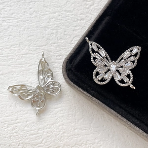 Detailed view of silver butterfly charms with clear zircons for DIY jewelry making