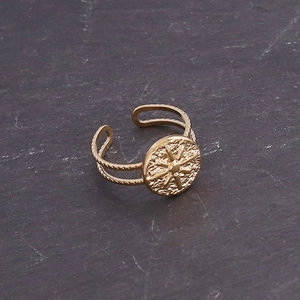 Detailed macro of gold-plated stainless steel ring with sunburst motif on stone