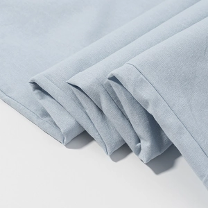 Close-up of light blue cotton linen fabric texture showing soft weave and quality