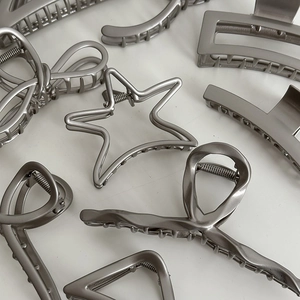 Various silver alloy hair claws featuring star and bow designs on a white background
